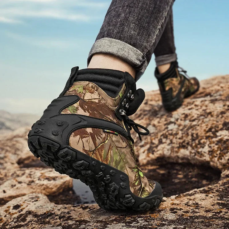 Hiking with TerraGuard Tactical Boots in camouflage, showcasing waterproof and slip-resistant features on rocky terrain.